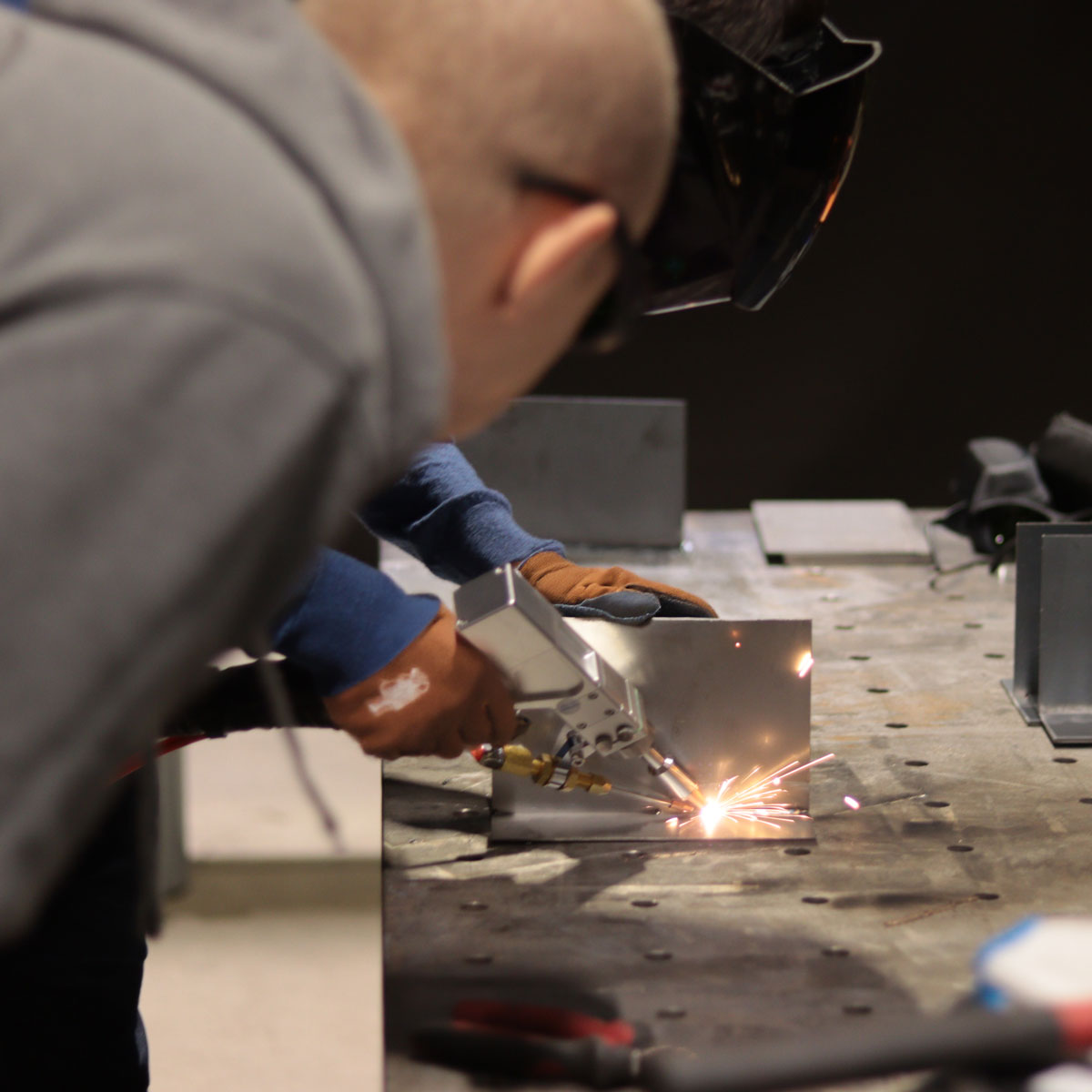 Spawacz wykonujący ręczne spawanie laserowe metodą 521 w certyfikowanym ośrodku szkoleniowym.